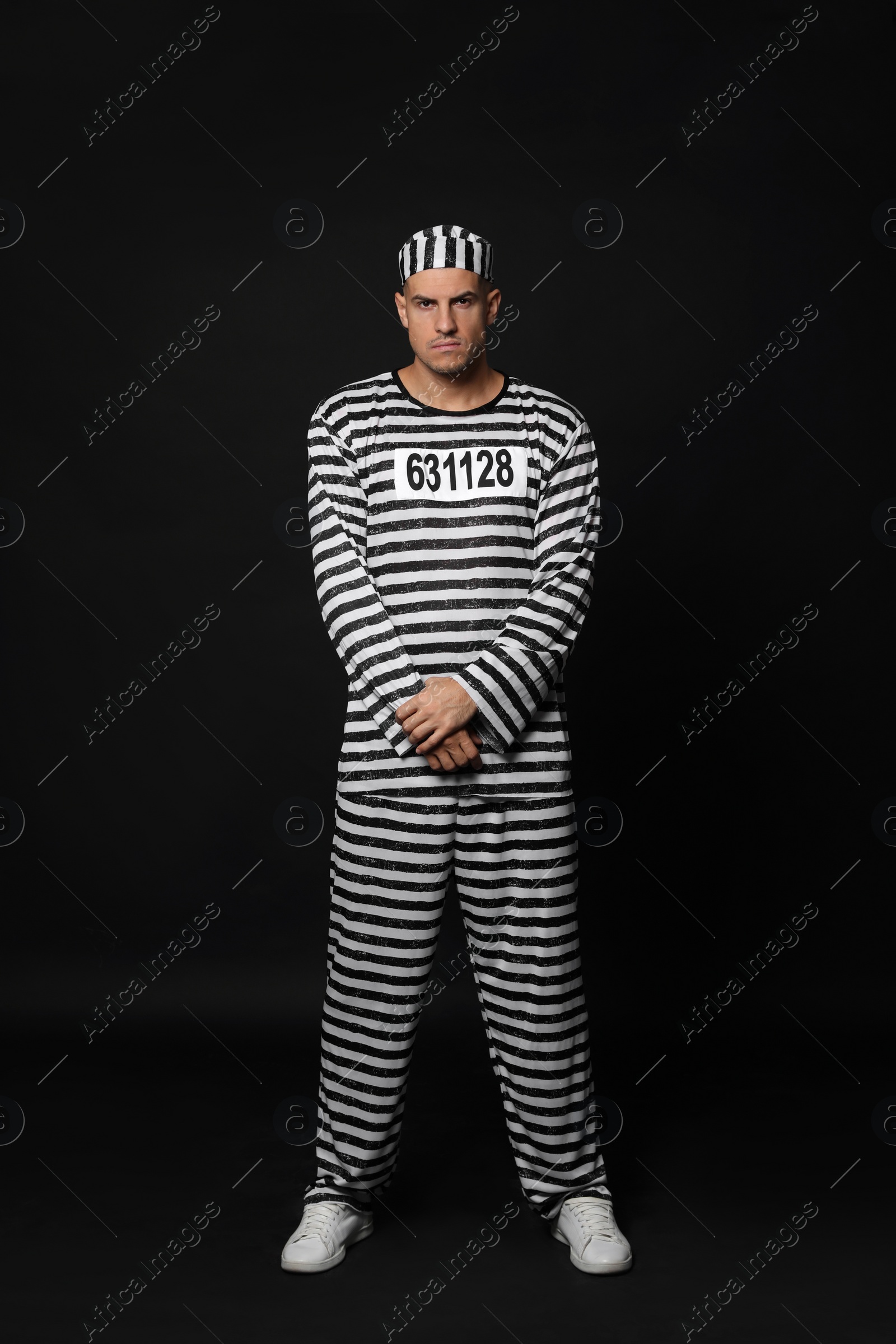 Photo of Prisoner in striped uniform on black background