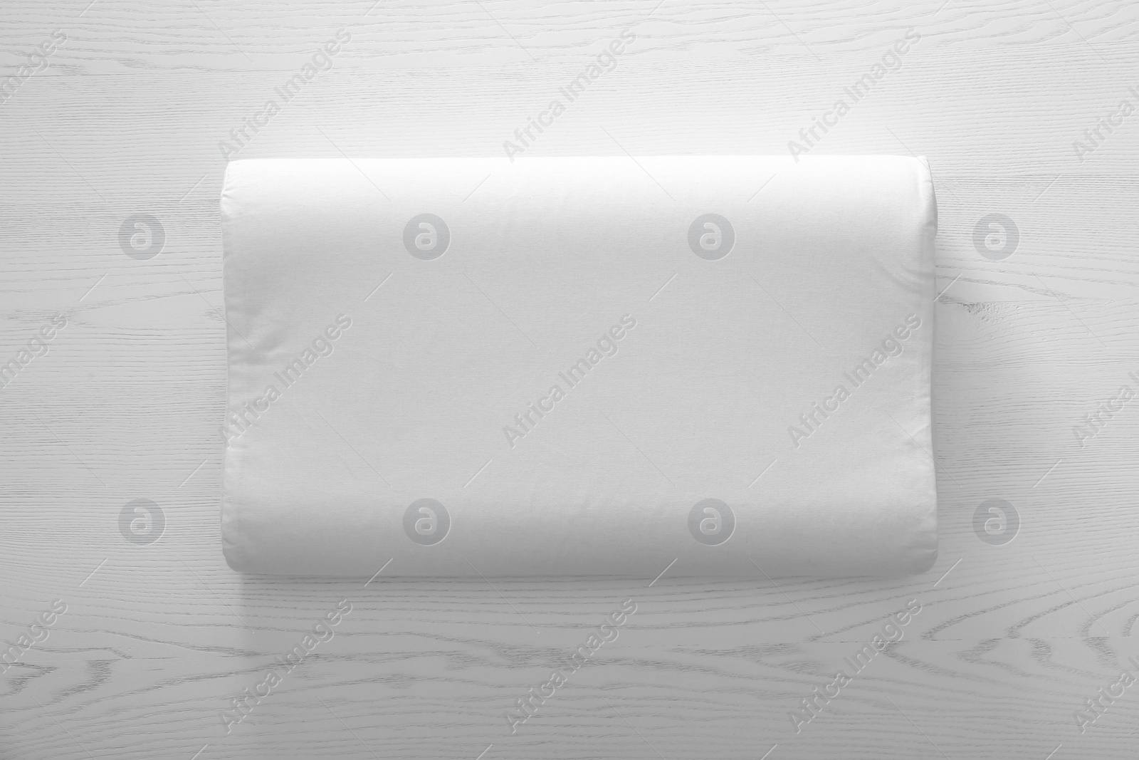 Photo of Soft bed pillow on wooden background, top view