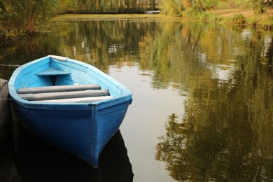 Photo of Light blue wooden boat on lake, space for text