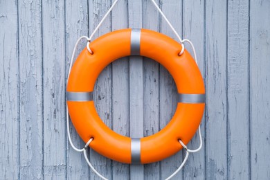 Photo of Orange life buoy hanging on light wooden wall