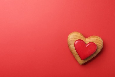 Wooden hearts on red background, top view. Space for text