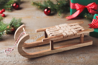 Photo of Sleigh and Christmas decorations on wooden table, closeup