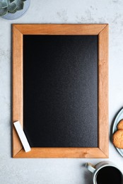 Photo of Clean small chalkboard, coffee and cookies on light grey table, flat lay