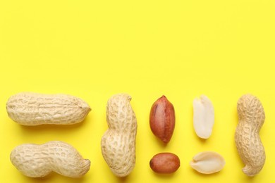 Photo of Fresh peanuts on yellow background, flat lay. Space for text