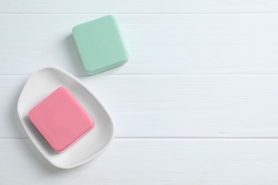 Photo of Soap bars on white wooden table, flat lay. Space for text