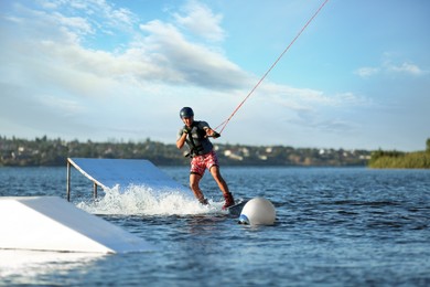 Photo of Teenage boy wakeboarding on river. Extreme water sport