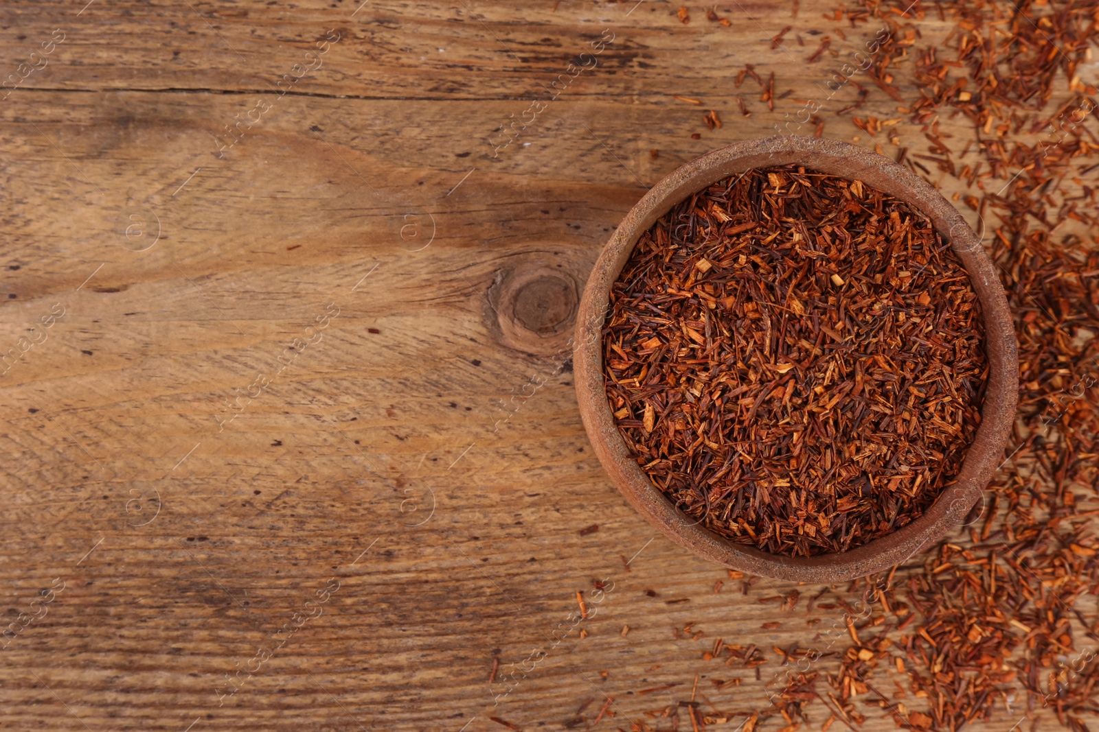 Photo of Dry rooibos leaves on wooden table, flat lay. Space for text