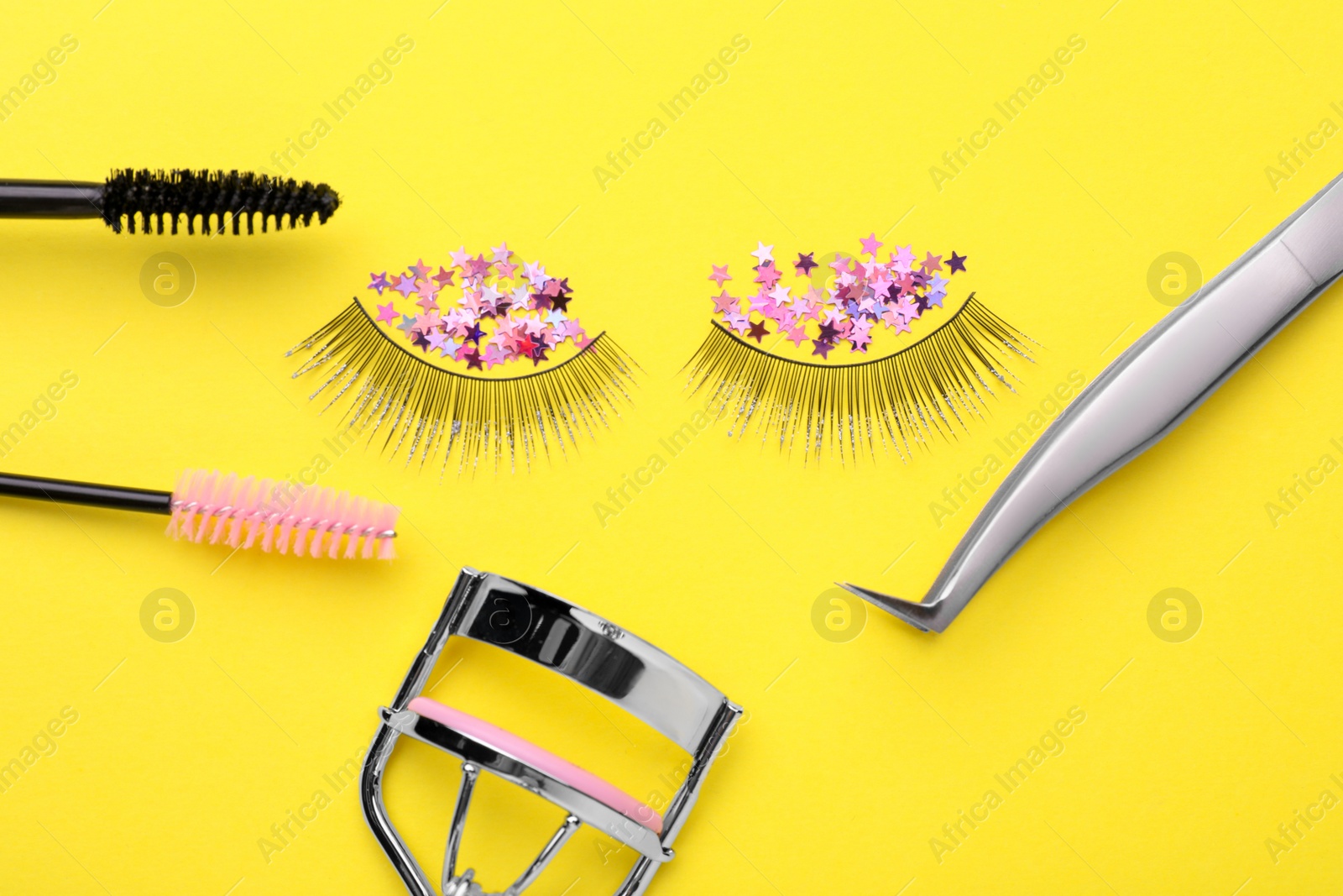 Photo of Flat lay composition with false eyelashes on yellow background