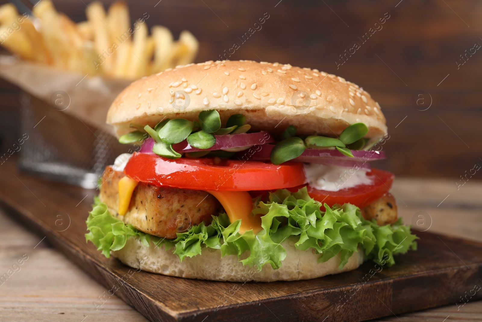 Photo of Delicious tofu burger served with french fries on table, closeup