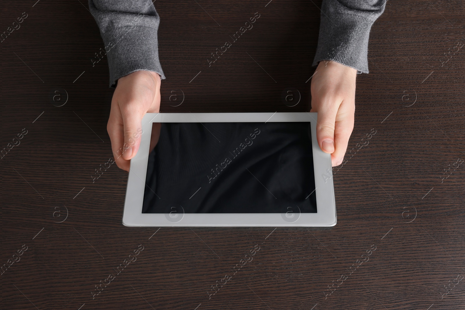 Photo of Man working with tablet at wooden table, top view