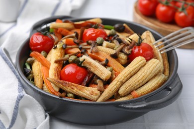 Photo of Tasty roasted baby corn with tomatoes, capers and mushrooms on white tiled table, closeup