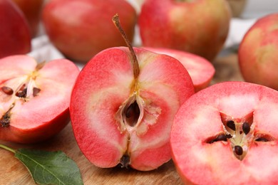Photo of Tasty apples with red pulp on wooden board, closeup