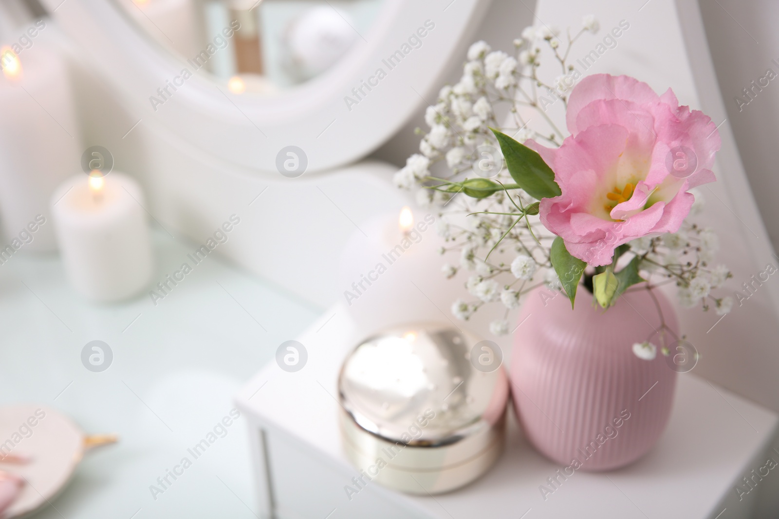 Photo of Beautiful flowers in vase and decor on white dressing table