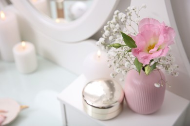 Photo of Beautiful flowers in vase and decor on white dressing table