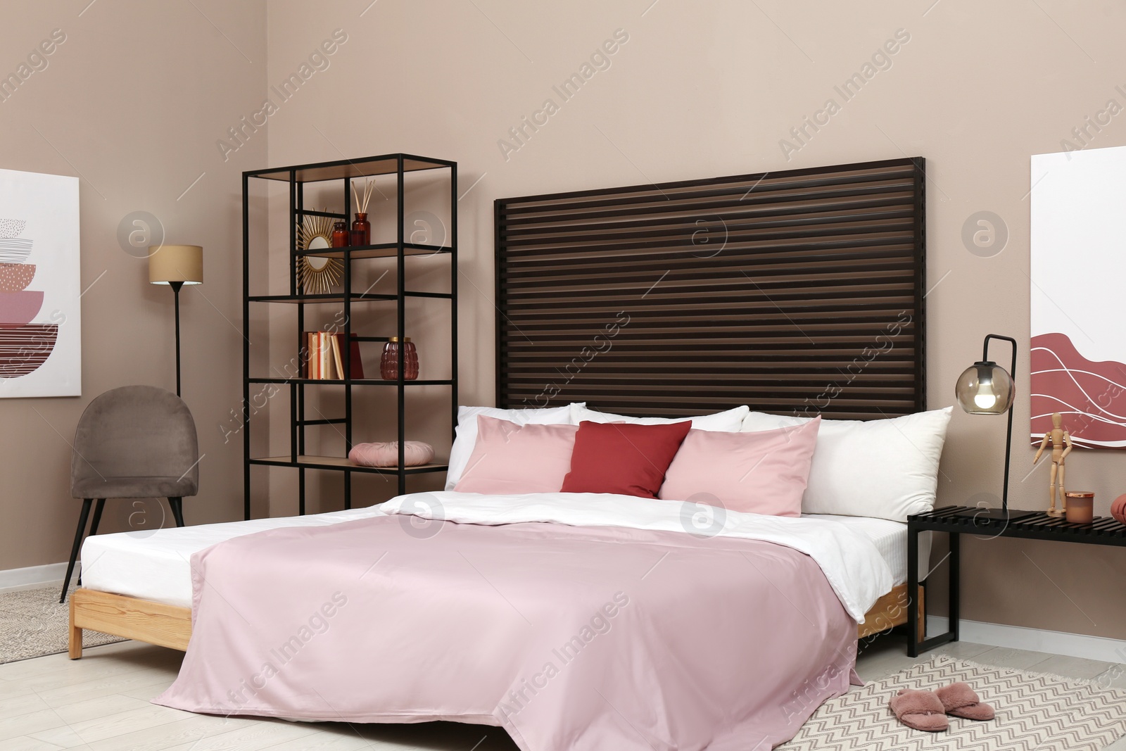 Photo of Large comfortable bed near beige wall in room. Interior design