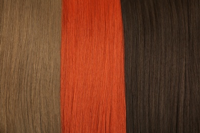 Photo of Hair strands of different color as background, top view