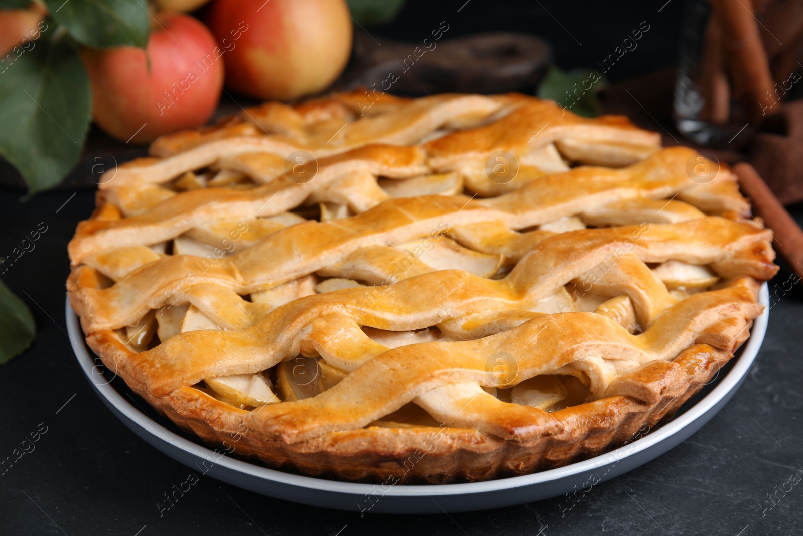 Photo of Delicious traditional apple pie on black table, closeup