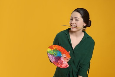 Photo of Woman with painting tools on yellow background, space for text. Young artist