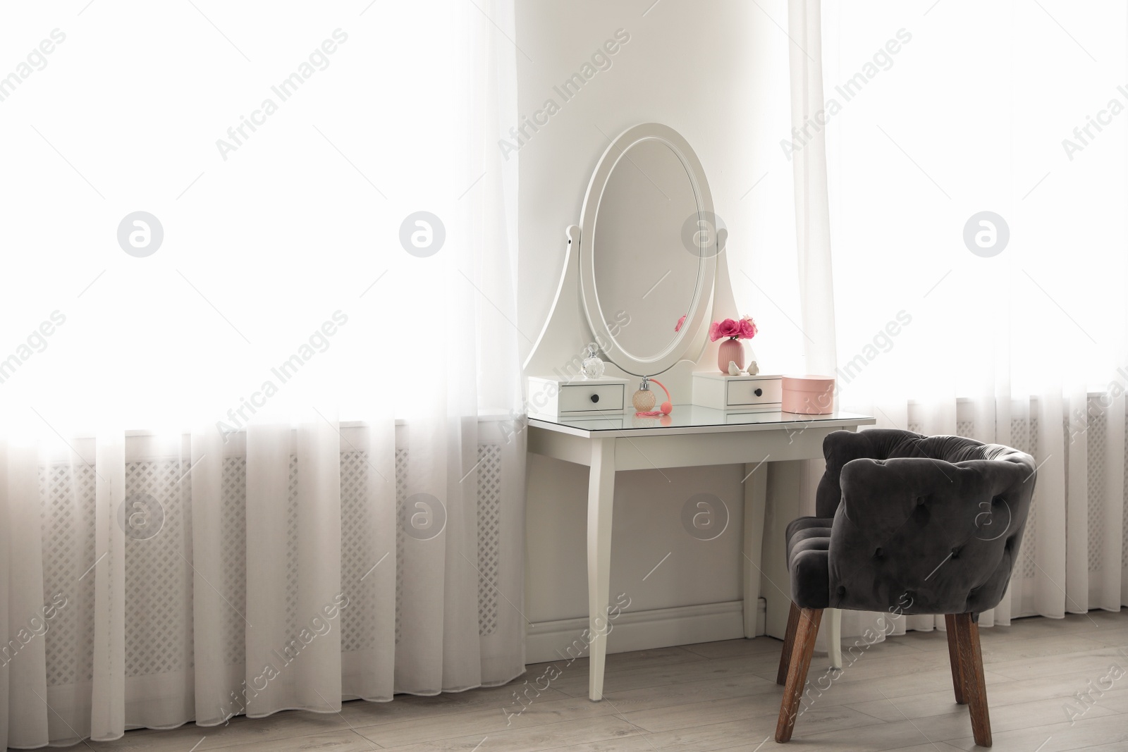 Photo of Elegant white dressing table and armchair in light room