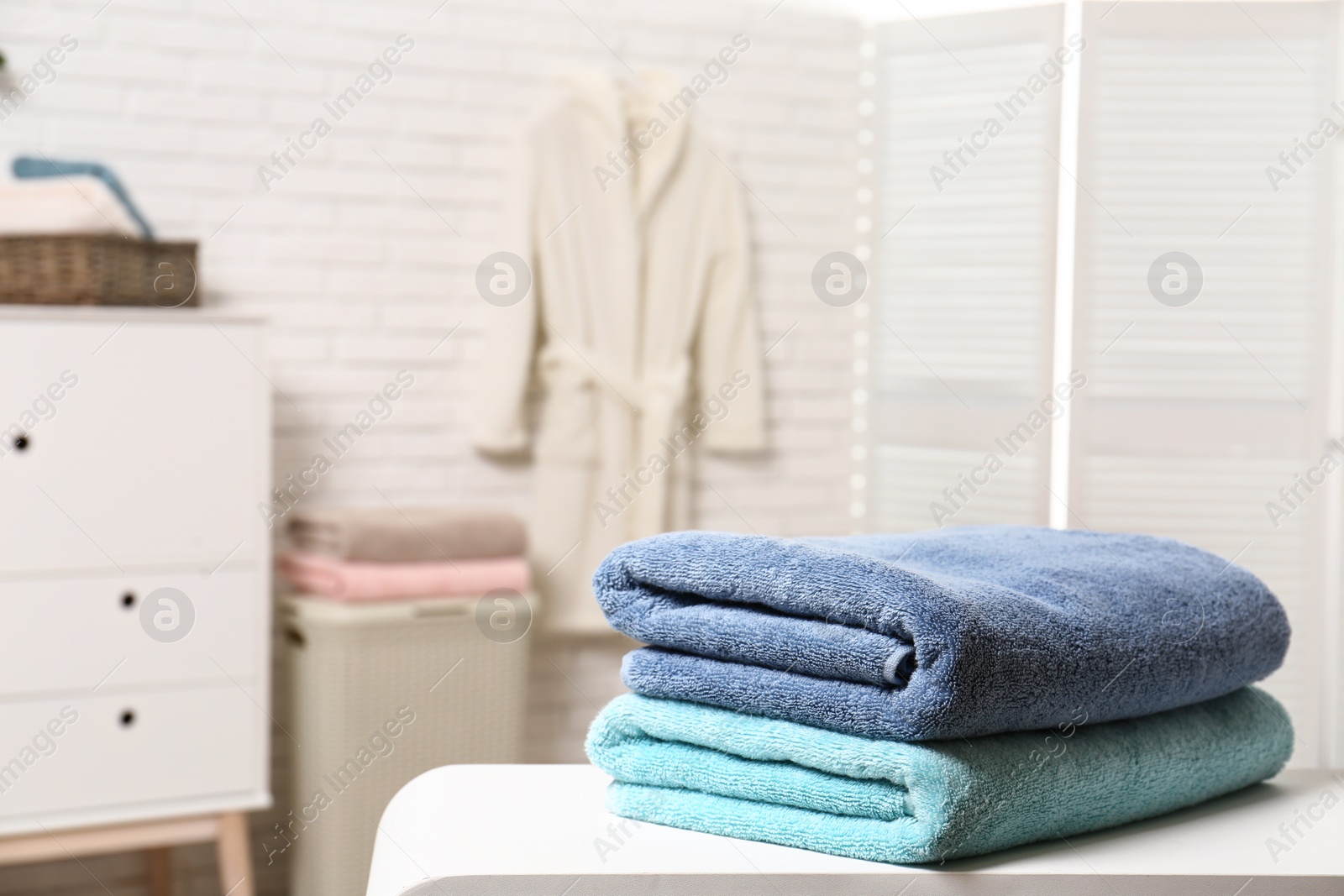Photo of Clean folded towels on table in bathroom. Space for text