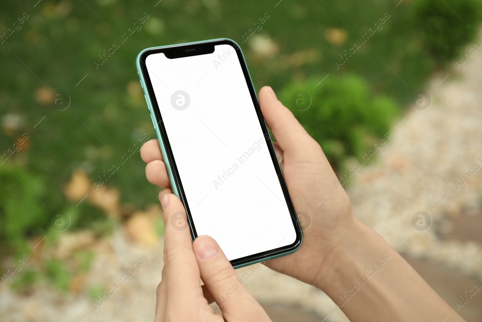 Photo of MYKOLAIV, UKRAINE - JULY 8, 2020: Woman holding Iphone 11 Pro Max with blank screen outdoors, closeup