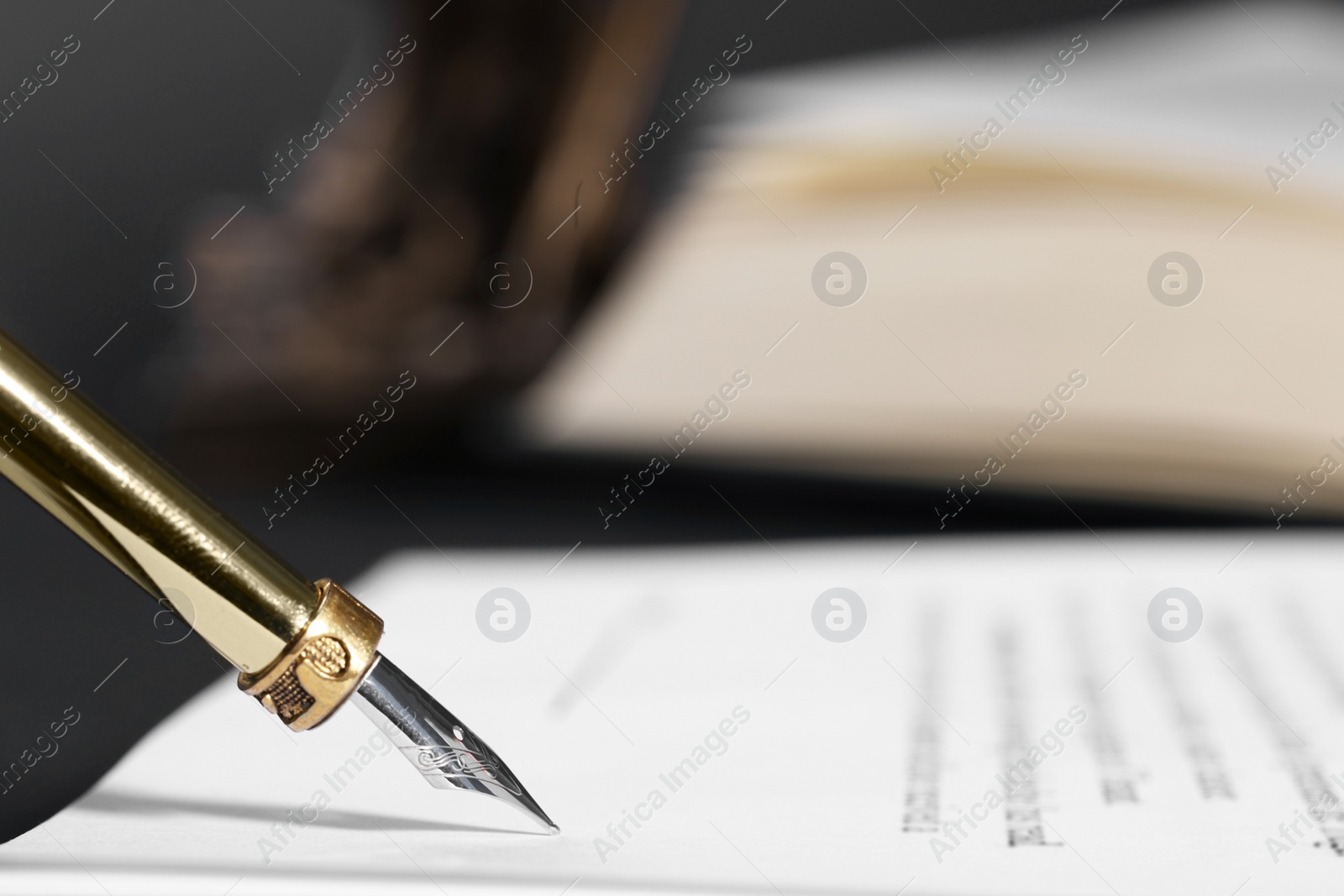 Photo of Writing on document with fountain pen at table, closeup and space for text. Notary contract