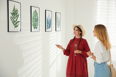 Photo of Young women at exhibition in art gallery