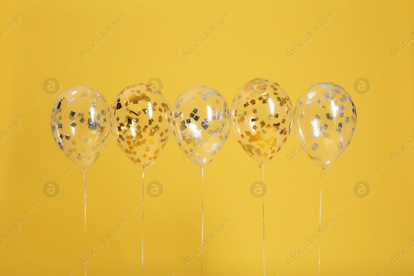 Photo of Bright balloons with ribbons on color background