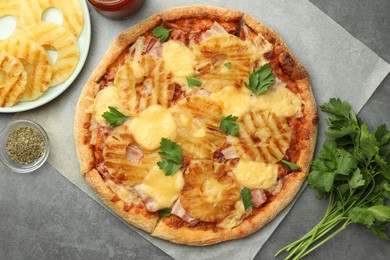 Delicious pineapple pizza and ingredients on gray table, flat lay