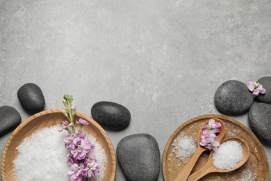 Flat lay composition with sea salt and spa stones on grey marble table. Space for text