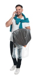 Photo of Man holding garment cover with clothes while talking on phone, isolated on white. Dry-cleaning service