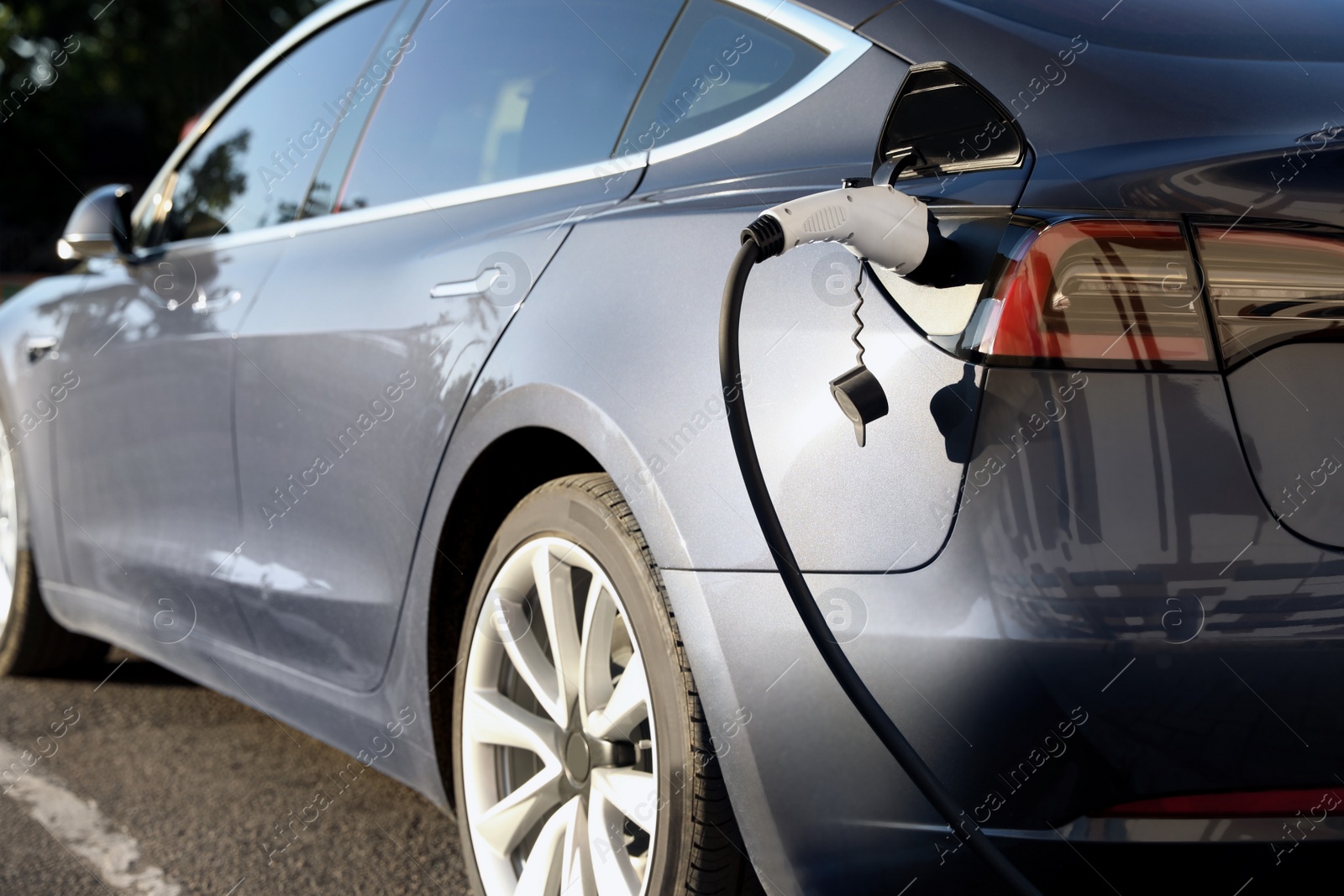 Photo of Charging modern electric car from station outdoors