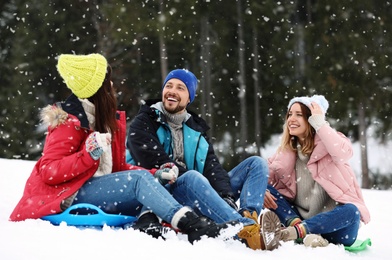 People with plastic sleds outdoors. Winter vacation