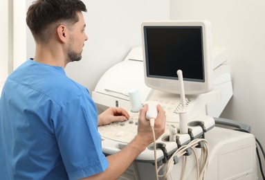 Photo of Sonographer operating modern ultrasound machine in clinic