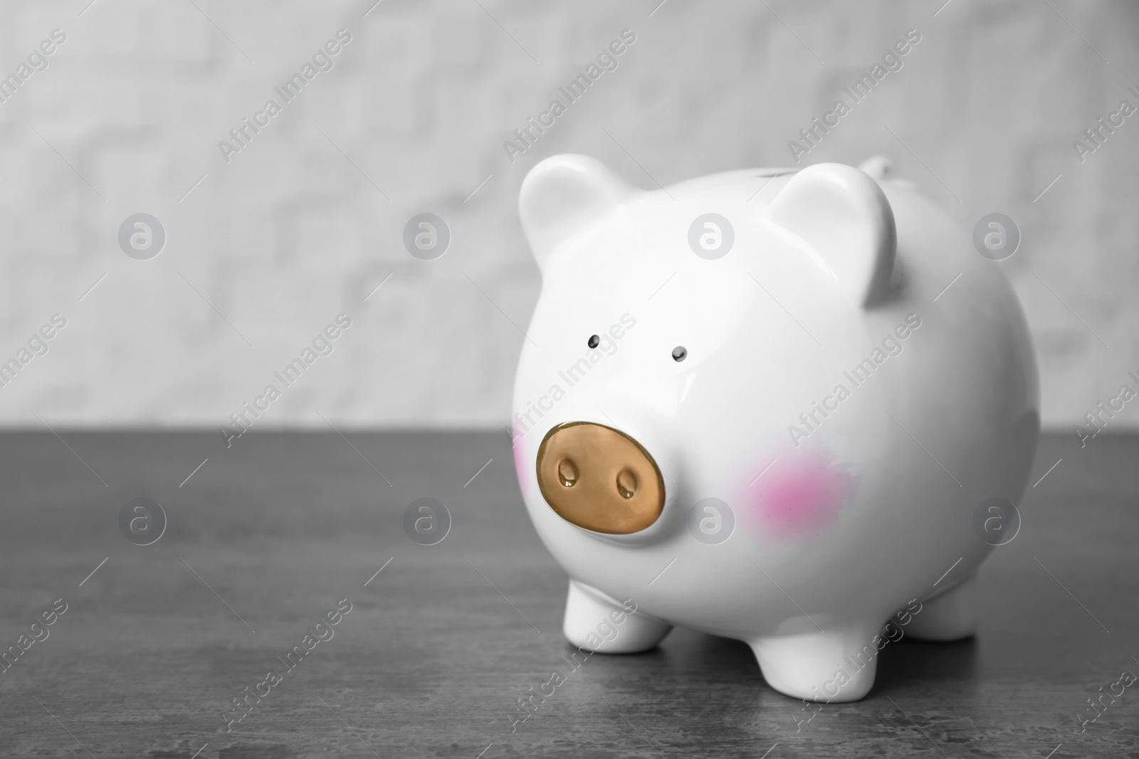 Photo of White piggy bank on gray table. Money saving