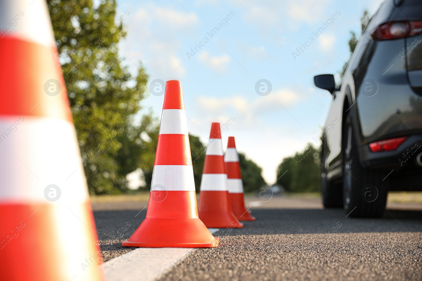 Photo of Traffic cones near car outdoors. Driving school exam
