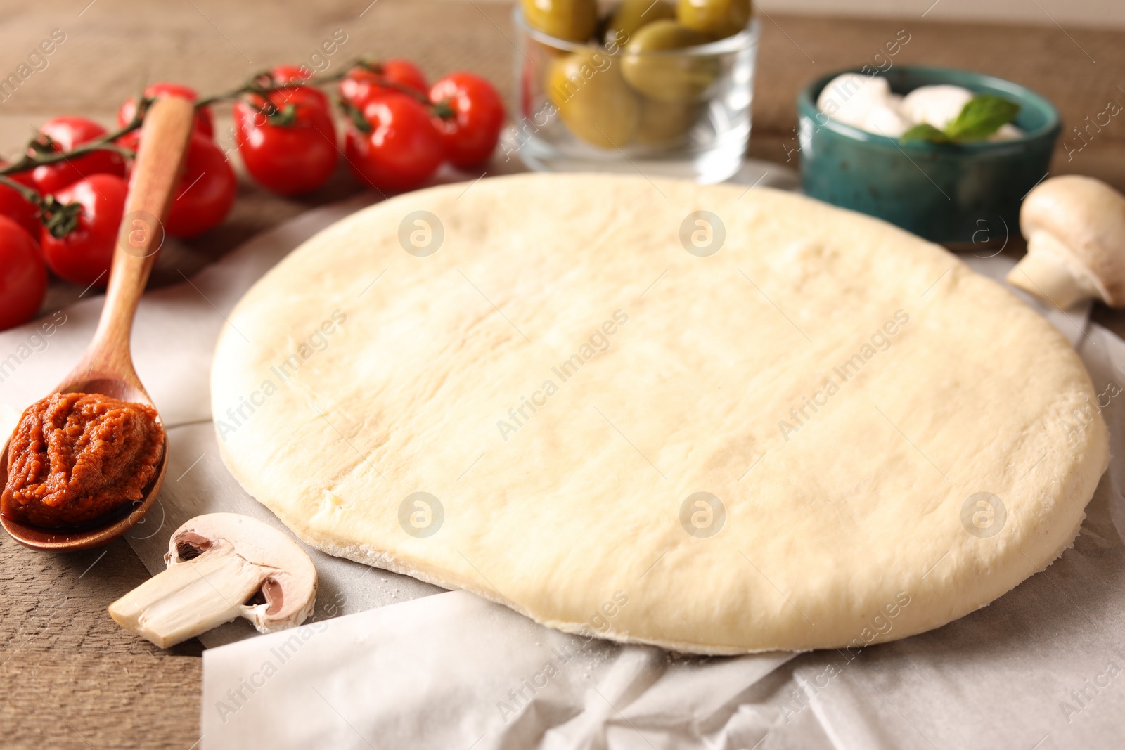 Photo of Pizza dough and products on table, closeup