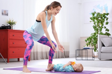 Photo of Young sportive woman doing exercise with her son at home, space for text. Fitness training