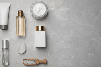 Flat lay composition with cosmetics on grey marble table, space for text. Spa treatment