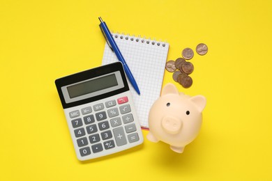 Photo of Calculator, piggy bank, notebook and coins on yellow background, flat lay