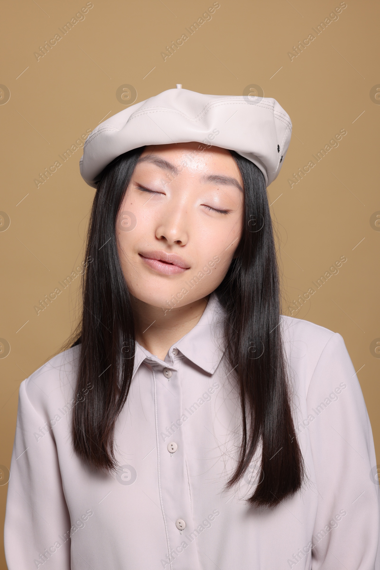 Photo of Portrait of beautiful young Asian woman in stylish outfit on beige background