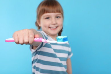 Photo of Little girl with toothbrush on color background. Teeth care