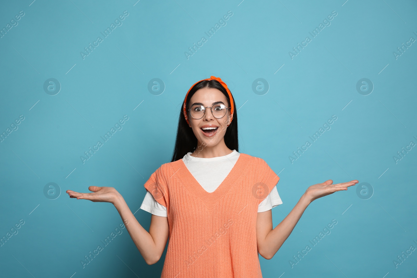 Photo of Young woman wearing stylish bandana on light blue background