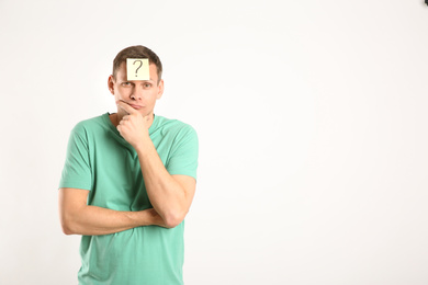 Photo of Thoughtful man with question mark on white background