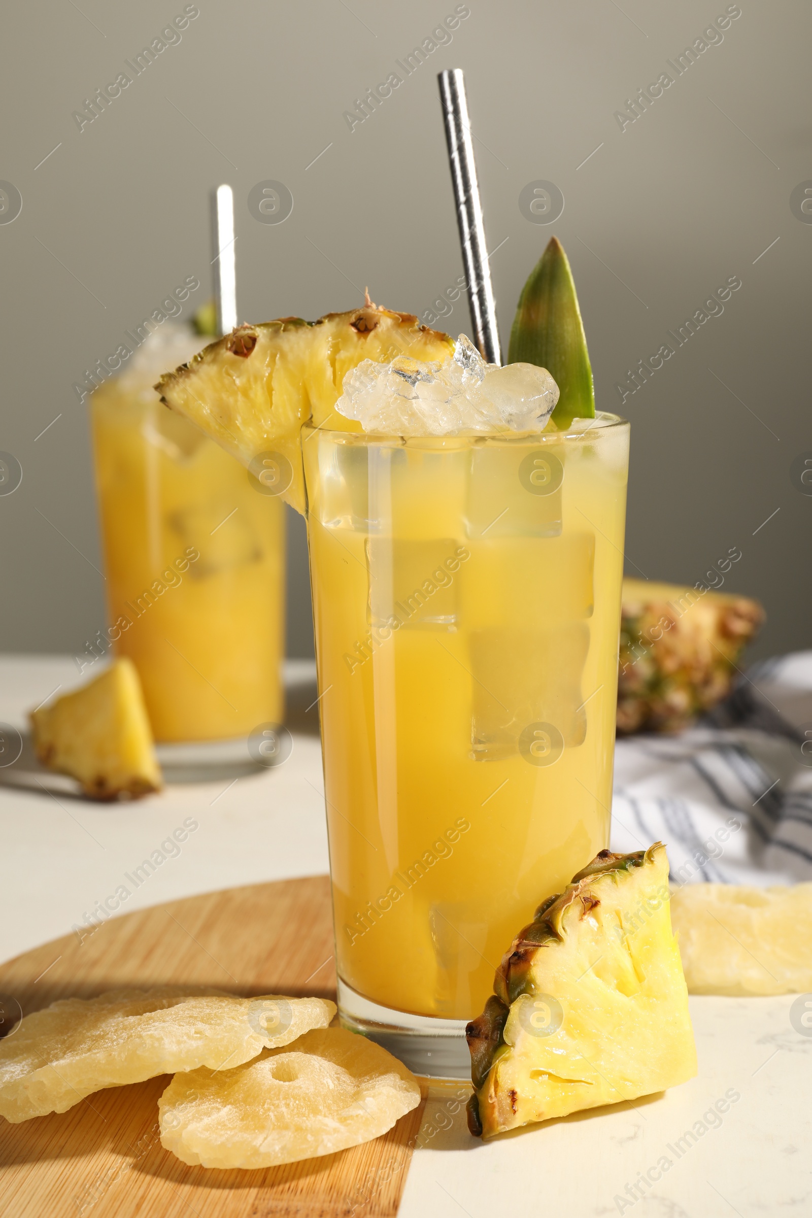 Photo of Tasty pineapple cocktail with ice cubes and delicious fruit on white table