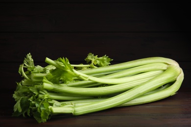 Photo of Fresh ripe green celery on wooden table