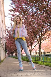 Young woman roller skating in spring park