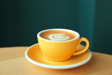 Photo of Cup of delicious coffee on wooden table indoors, closeup