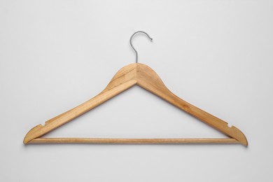 Photo of Empty wooden hanger on light grey background, top view