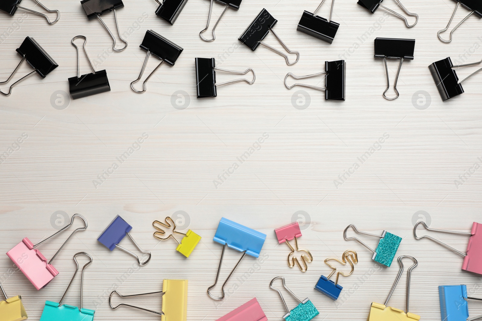 Photo of Binder clips on white wooden background, flat lay. Space for text